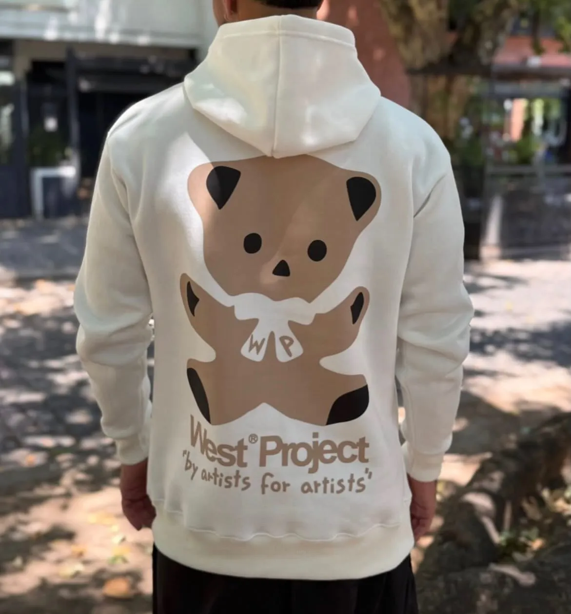 Hoodie blanco West Project con estampa de oso, visto de espalda en exterior
